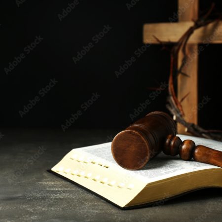Judge gavel, bible, wooden cross and crown of thorns on grey table. Space for text